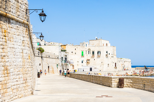 Beautiful seafront promenade of Giovinazzo, with the bastions of the old town on the left and the beach on the right. Giovinazzo, Apulia, Italy, August 2017