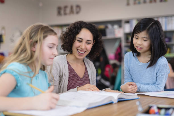istock Teacher helping 4th graders in her classroom 986222894