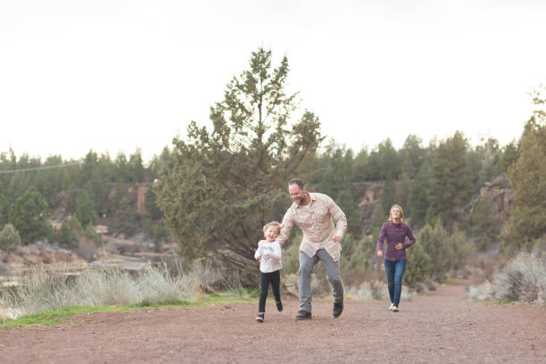 istock Dad Chases His Daughter on Hiking Trail 986254828