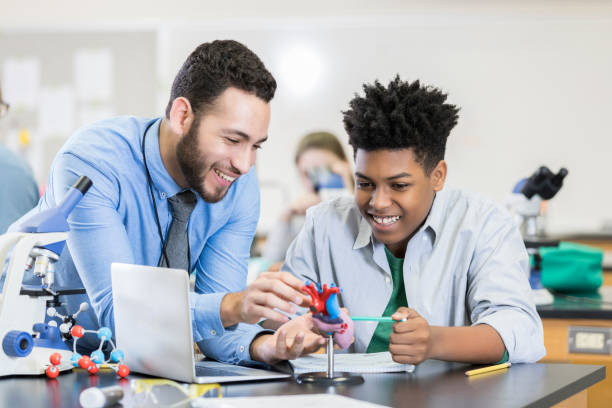istock Teenage boy receives help from attentive science teacher 986272220