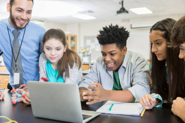 istock High school science teacher shows laptop video to students 986272236