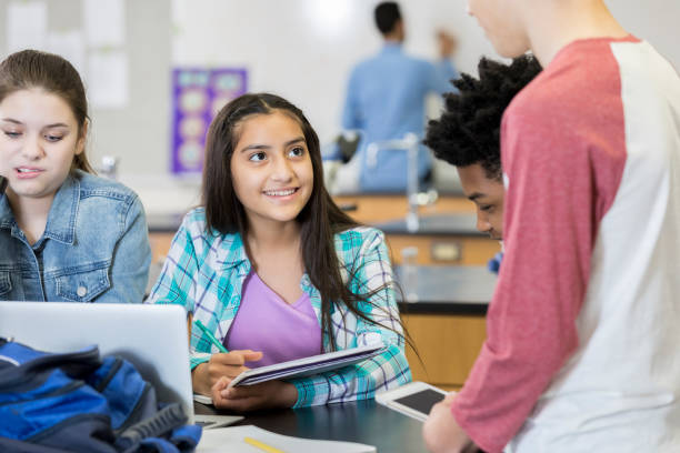 istock Teenage girl records experiment data in science class 986272242