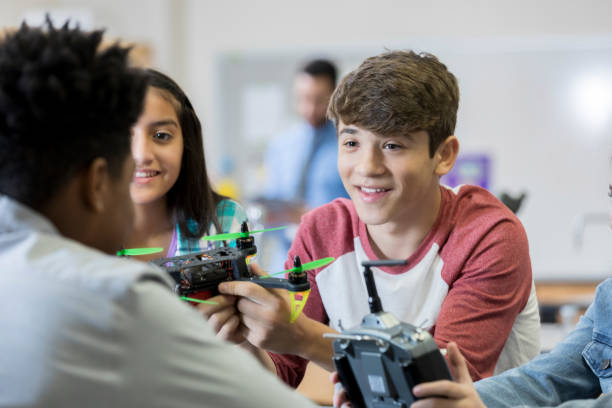 istock Teenage boy discusses robotics project with classmates 986272244