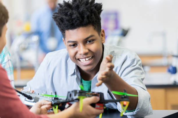 istock Teenage boy fine tunes kit with robotics lab partner 986272246