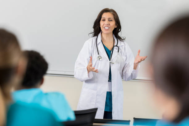 mature hispanic doctor teaches a med school class - teaching seminar presentation classroom imagens e fotografias de stock