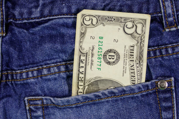 istock Five dollars banknote in the pocket of blue jeans 986316938