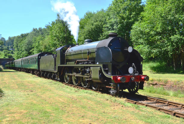 istock Vintage steam train emerging from a tunnel on a heritage railway line. 986343030