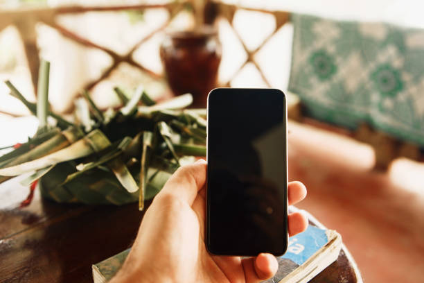 Male hand holds mobile phone with blank screen close up
