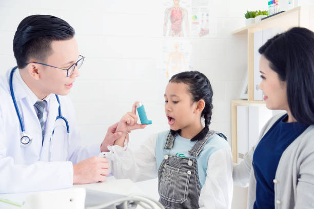 lekarz wyjaśnia dziewczynie metodę inhalatora astmy. - asthmatic child asthma inhaler inhaling zdjęcia i obrazy z banku zdjęć