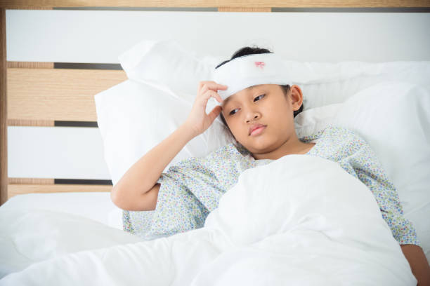 girl with head injury resting on bed in hospital stock photo