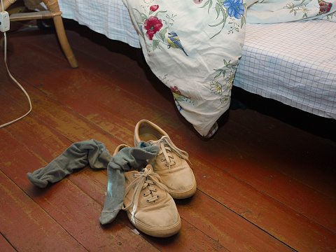 Shoes and unmade bed
