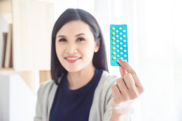 woman holding contraceptive pills and smiles,focus at contraceptive pills. stock photo