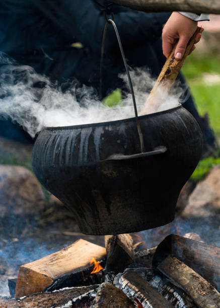 istock Big black cooking pot on fire outdoors 986432294