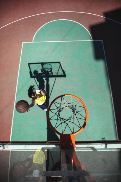 istock Street basketball player doing a slam dunk 986433346