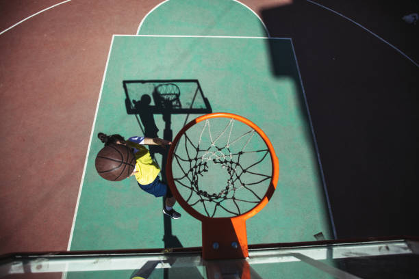 istock Street female basketball player doing a slam dunk 986433804