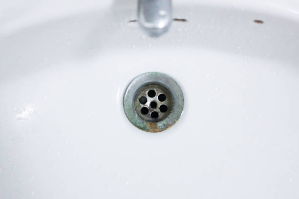 istock Water droplet, drain in white washbasin 986436636