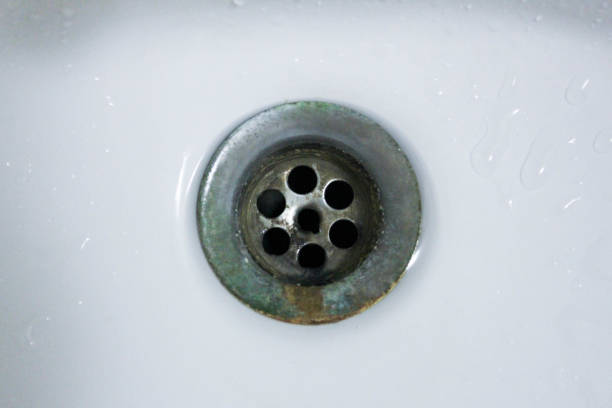 istock Water droplet, drain in white washbasin 986436640