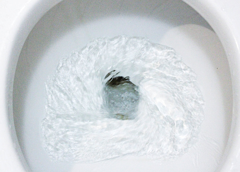 Toilet, Flushing Water, close up, water flushing in toilet, A photo of a white ceramic toilet bowl in the process of washing it off. Ceramic sanitary ware for correcting the need with an automatic flushing device