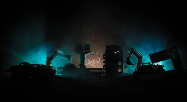 istock Construction site on a city street. A yellow digger excavator parked during the night on a construction site. Industrial concept table decoration on dark foggy toned background 986437154