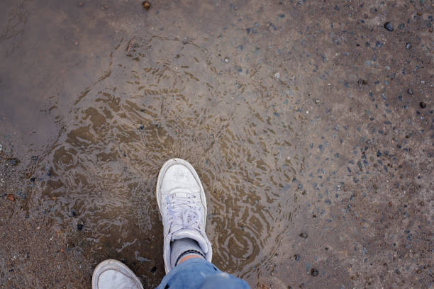 istock Female feet pacing in puddles during the rain 986438658