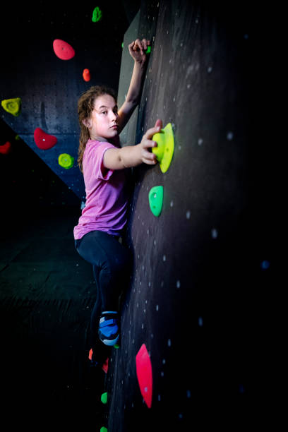 adolescente de negociar seu caminho até uma parede de escalada - climbing wall rock climbing holding reaching - fotografias e filmes do acervo