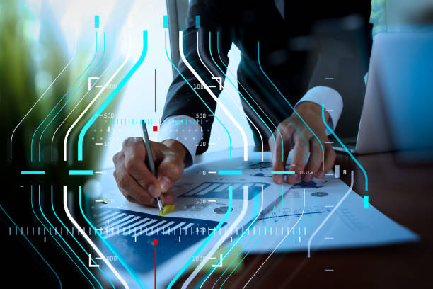 istock businessman hand working with new modern computer and business strategy documents with green plant foreground 986455070
