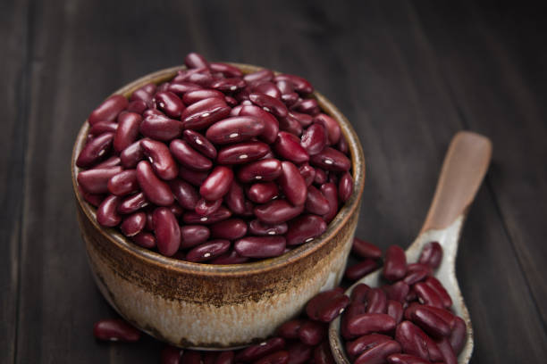 istock Kidney beans or red beans in a ceramic bowl and in a ceramic spoon on wooden table. 986464032