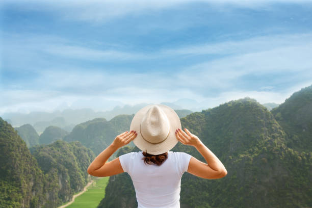 istock back view woman enjoying the mountain view from the peak with blue sky 986469456