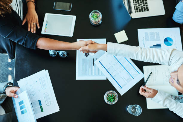 An agreement has been settled Shot of businesspeople shaking hands during a meeting in an office mergers and acquisitions photos stock pictures, royalty-free photos & images