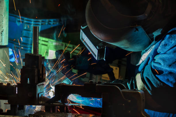 istock Welder is welding automotive part in production line with protective mask 986471000
