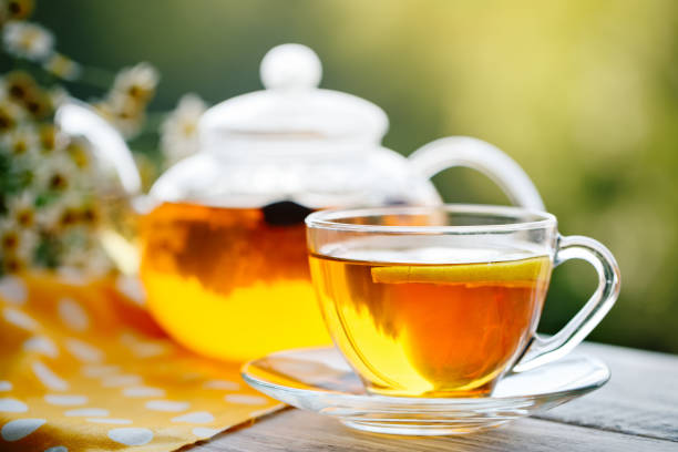 istock Cup with hot tea with mint and a thyme on a wooden table in a summer garden 986474704