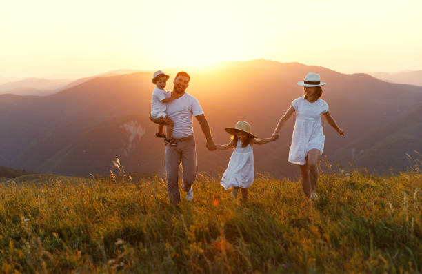 istock Happy family: mother, father, children son and daughter on sunset 986476256