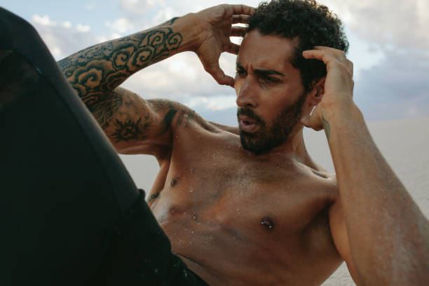istock Muscular man doing sit-ups outdoors 986484466