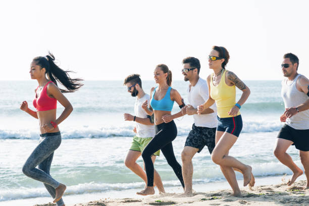 istock People jogging early in morning at the beach 986494608