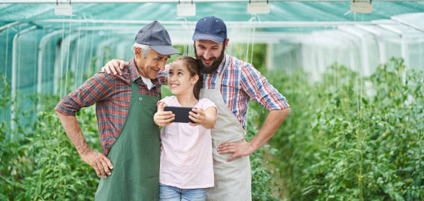 prise familiale selfie à effet de serre - casual granddaughter farmer expressing positivity photos et images de collection