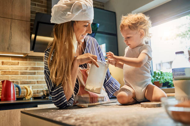istock young mother getting assistance in cooking by her baby 986513664