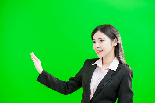 businesswoman touch virtual screen on the green background