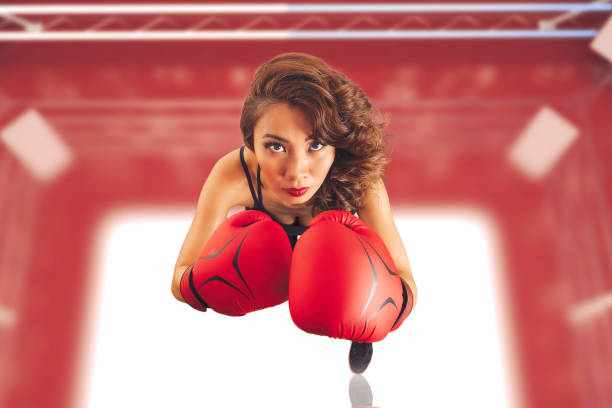 Female Asian boxer throwing punches in a boxing ring