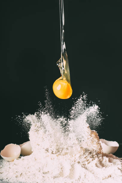 istock close up view of yolk falling on flour on black background 986525186