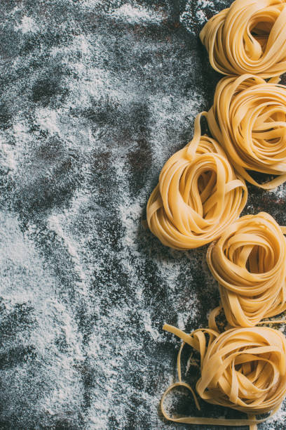 istock top view of raw tagliatelle pasta on table covered by flour 986528702