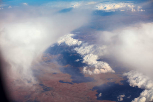 istock Aerial view through clouds. Airplane view of mountains with glacier 986529600