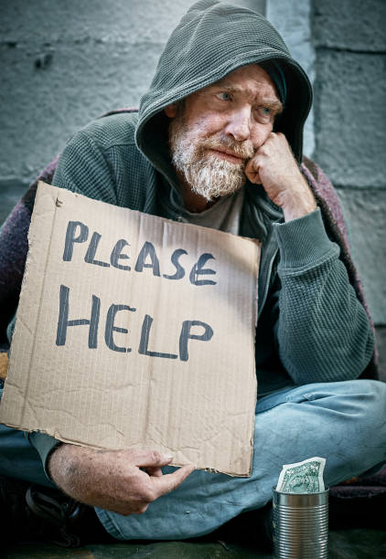 istock Tired and depressed beggar holding sign 