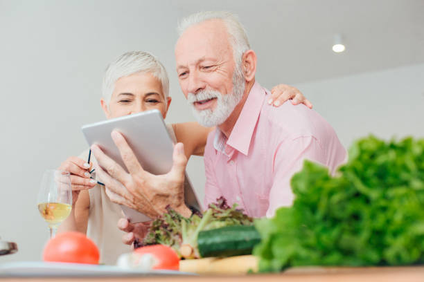 istock Seniors looking at digital tablet at the kitchen 986542108