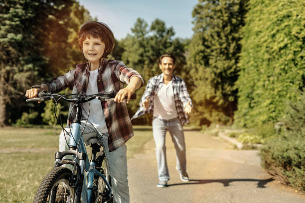 istock Boy riding his bicycle and his dad running 986551578