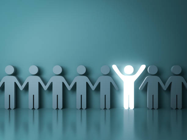 istock Stand out from the crowd and different creative idea concepts One glowing light man standing with arms wide open among other people on dark green background with reflections and shadows 3D rendering 986556912