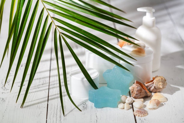 istock Cosmetic bottle containers with green herbal leaves 986557012