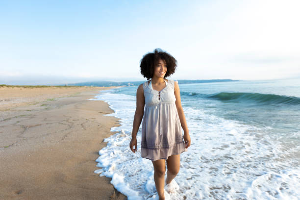 istock African woman walking on beach alone 986564376
