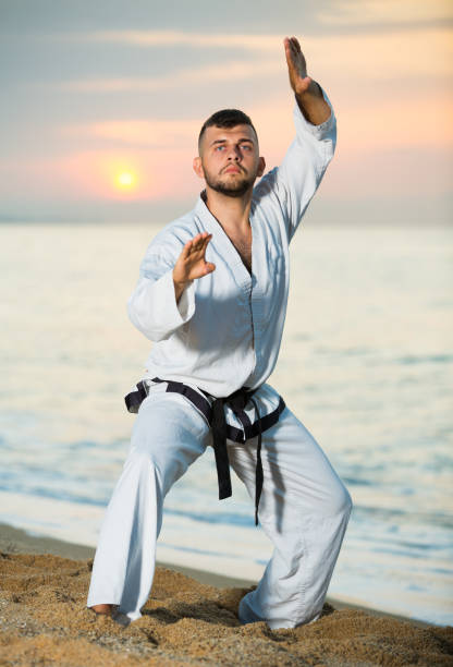 istock Smiling male doing karate at ocean quay 986572096