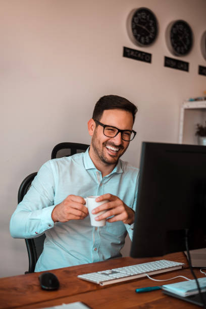 istock Smiling man communicating with his coworkers online. 986572158