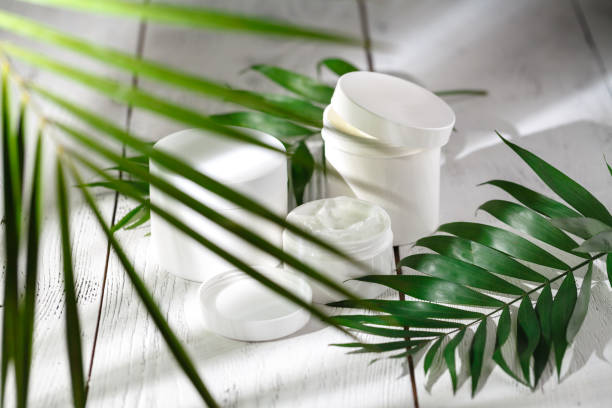 istock Cosmetic cream and beautiful spa containers on white table 986572876